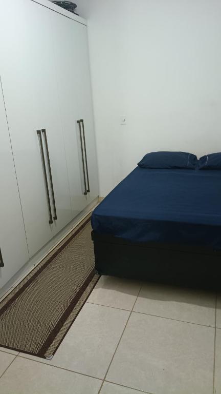 a bedroom with a bed and a wall with cabinets at Hostel Viracopos in Campinas