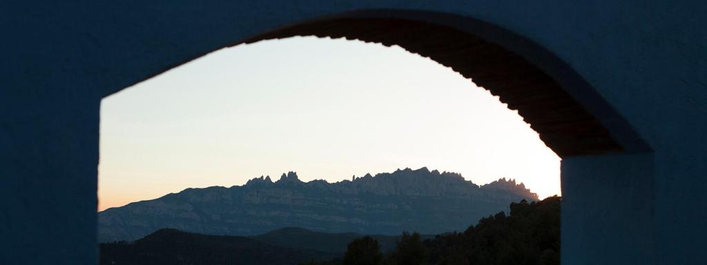 een boog met uitzicht op een berg bij Masia CasaJoana Rural in Rellinars