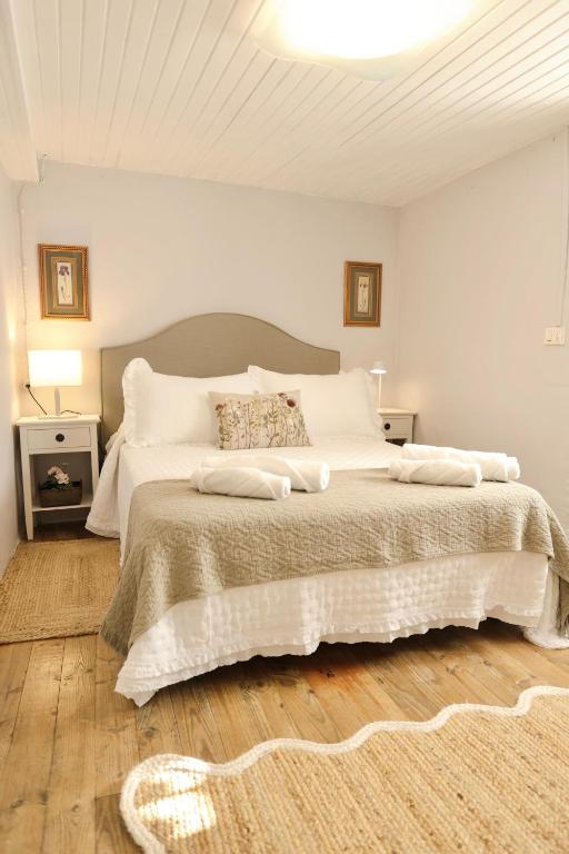 a bedroom with a large bed with white sheets at Casa da Juana in Chantada