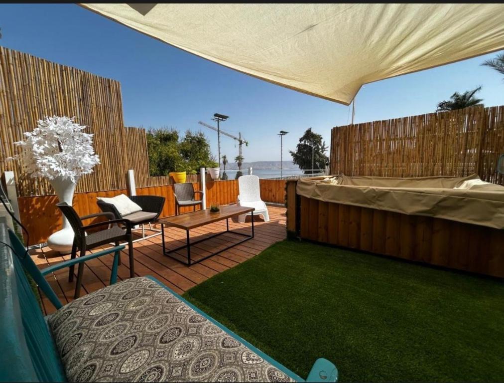 a patio with a table and chairs on a deck at דופלקס כנרת in Tiberias