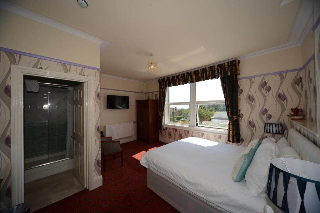 a hotel room with a bed and a window at Seabrook House Hotel in Hythe