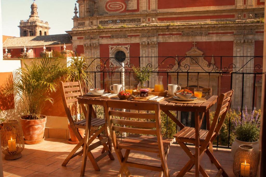 a table and chairs on a balcony with a meal on it at Panther Home Salvador in Seville