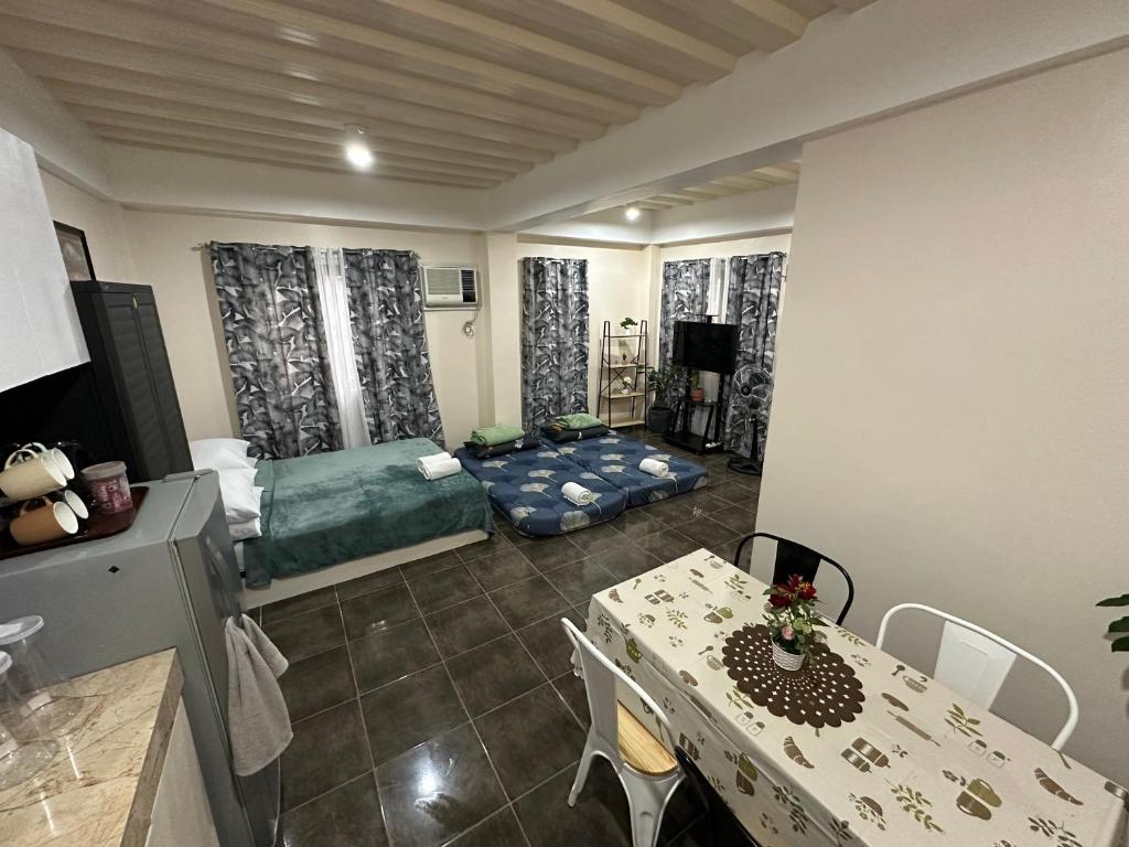 a living room with a dining table and a bedroom at The Uptown deluXE Studio #5 in Balulang