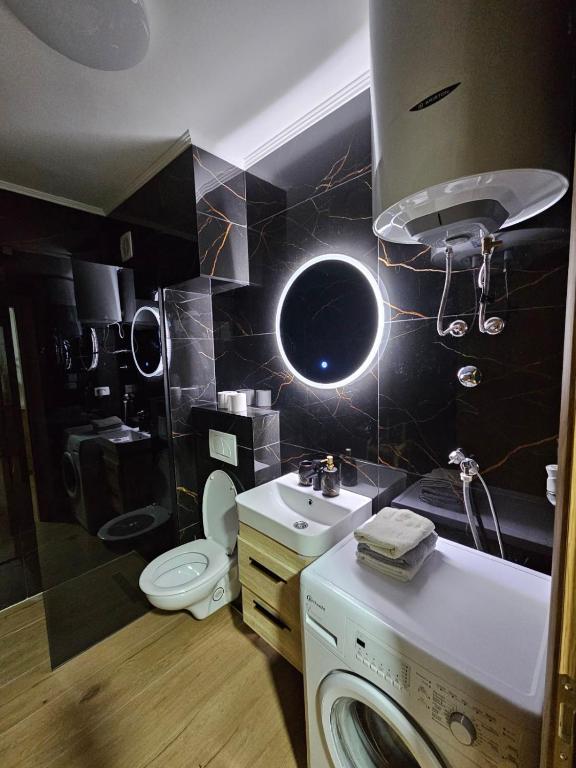 a bathroom with a sink and a washing machine at Luxury Apartment Lara Mostar in Mostar