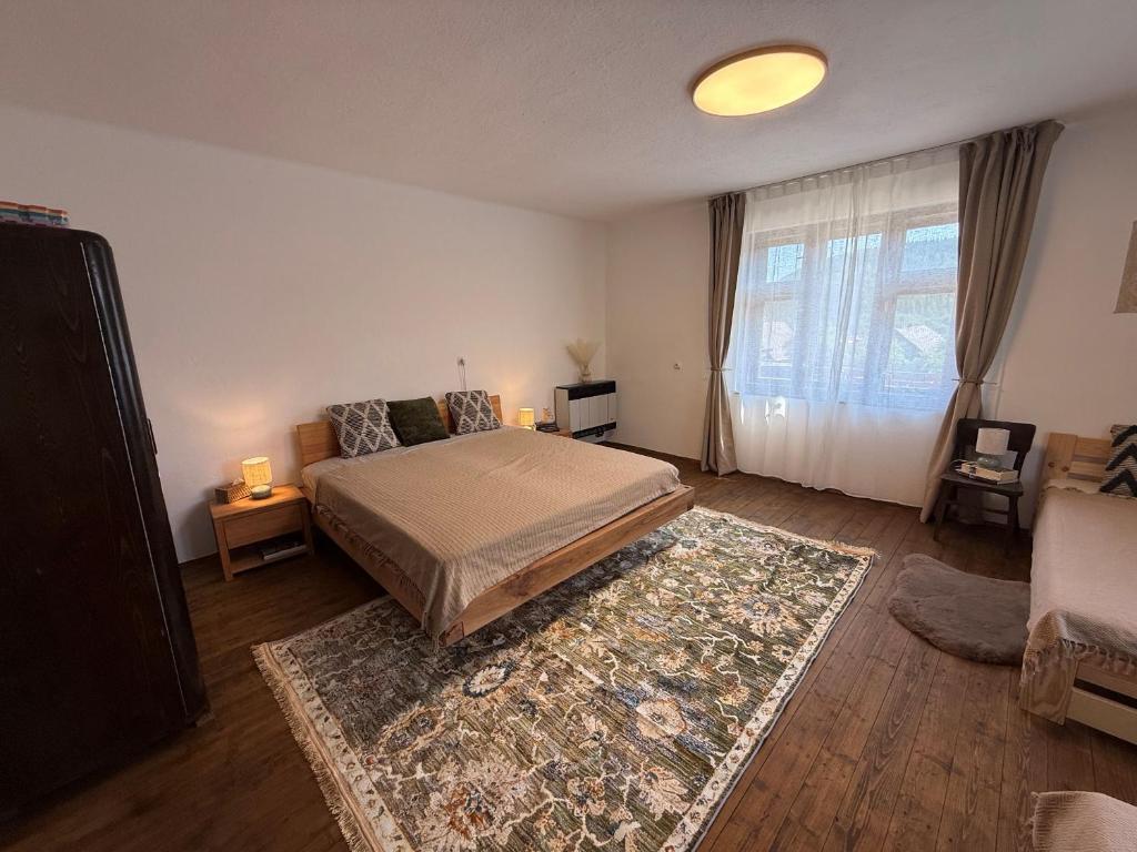 a bedroom with a bed and a rug at Dvor u Hrivka in Heľpa