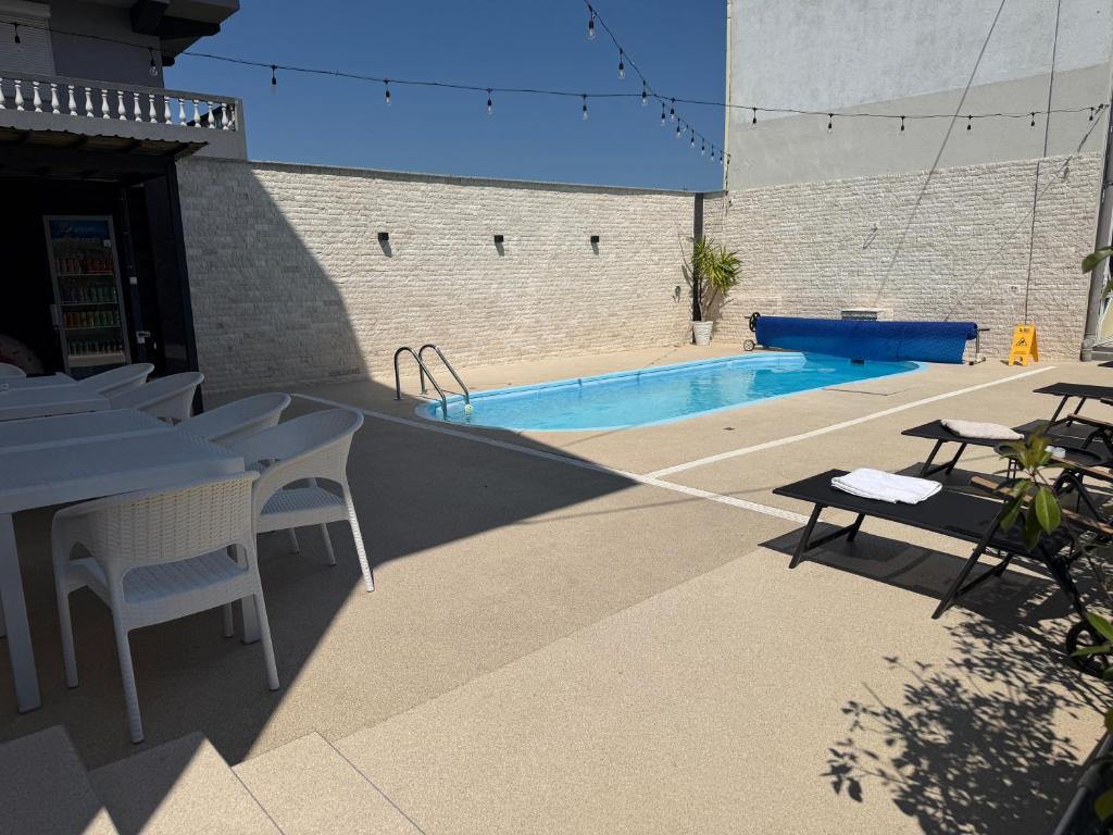 a swimming pool with a table and chairs next to a building at New Venus in Curtea de Argeş