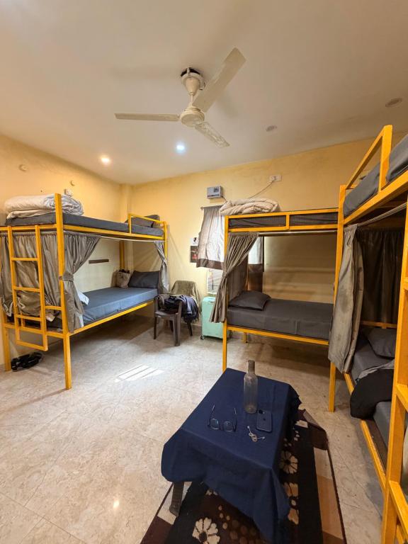 a room with three bunk beds and a table at The Third Space Varanasi in Rāmnagar