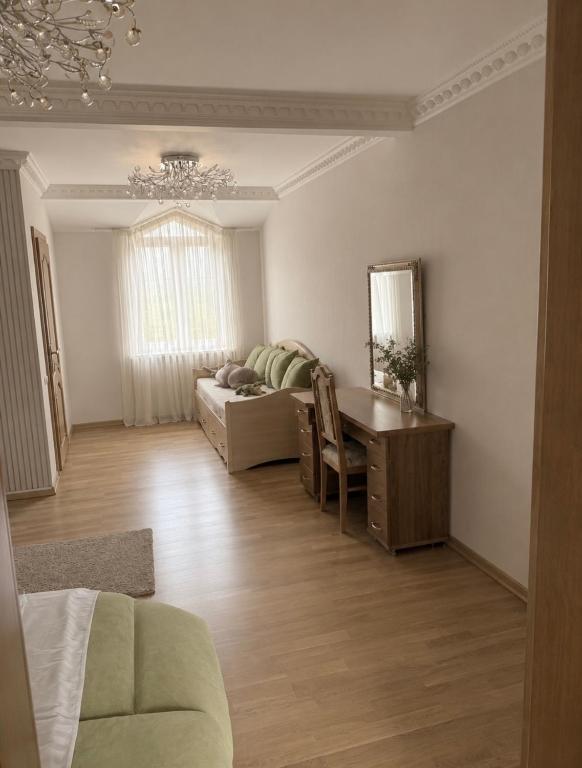 a living room with a table and a couch and a desk at Солочин Квітка Полонини Дом 63 in Solochyn
