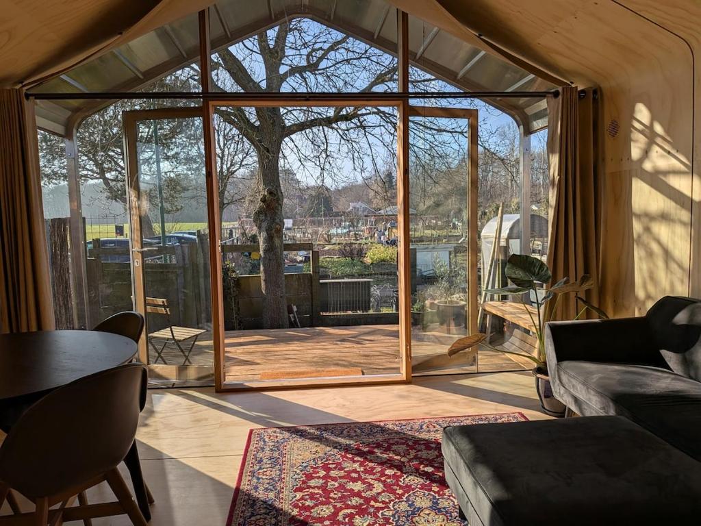 a living room with a large glass door at Bakkums Bosgeluk in Castricum