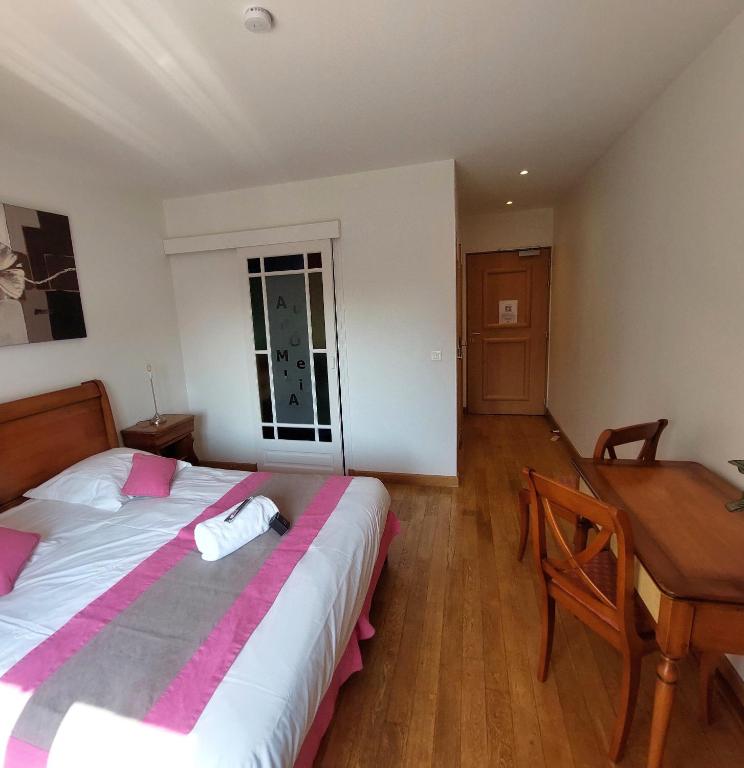 a bedroom with a bed and a desk and a table at Au Domelia Provinois - Chambres - in Cerneux