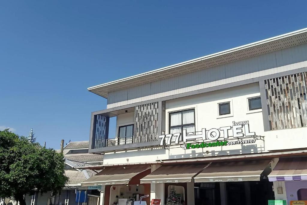 a hotel building with a balcony on a street at 777 Food & Bed in Chiang Rai
