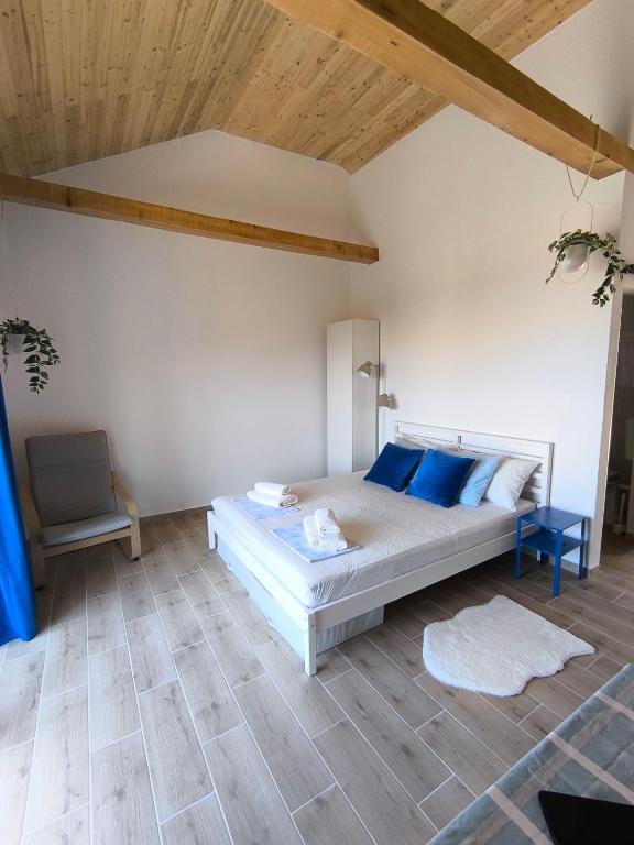 ein Schlafzimmer mit einem Bett mit blauen Kissen und einem Stuhl in der Unterkunft Pink Sunset in Lukovo