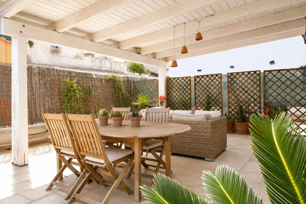 a patio with a wooden table and chairs at Bari LandLord 31- Old Town Apartment in Bari