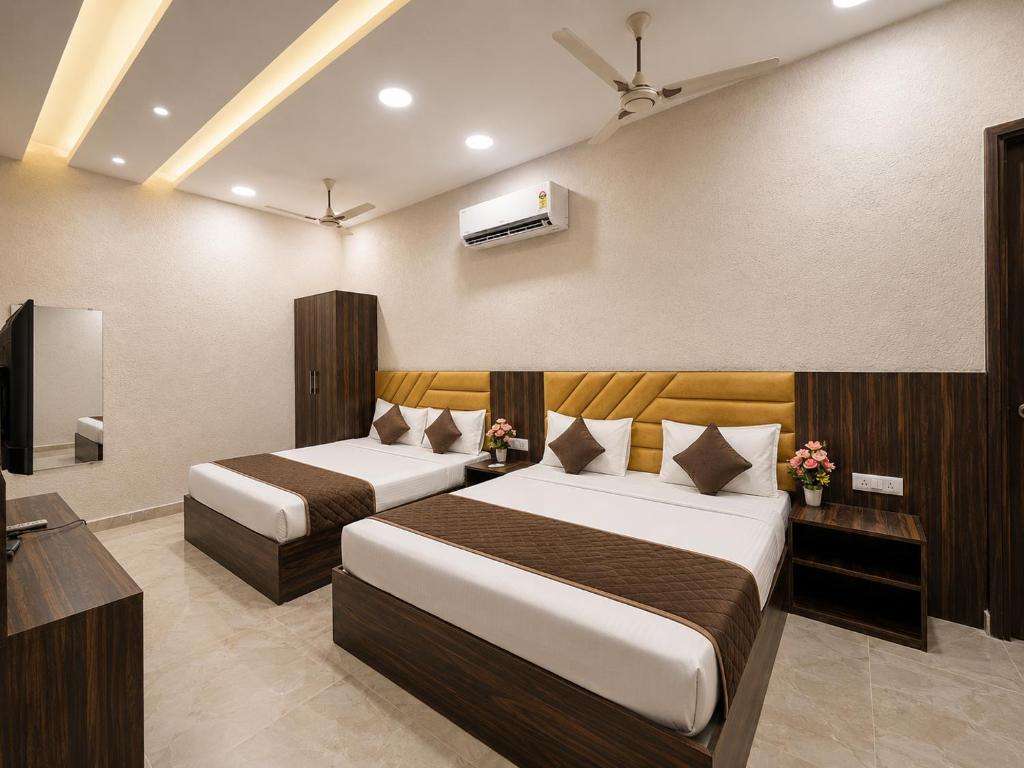 a hotel room with two beds and a television at Hotel KR Near Golden Temple in Amritsar
