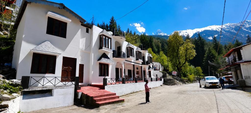 a person standing in front of a building on a street at Hotel Dharali Nature In Dharali in Gangnāni