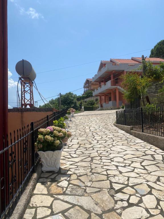 a stone walkway with potted plants on a fence at Marina View in Shëngjin