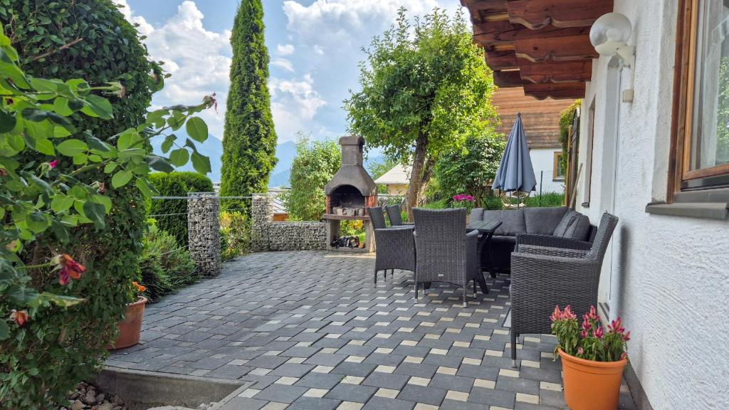 a patio with chairs and a table and a fireplace at Apartment FUCHSLEHEN with terrace and mountain view by All in One Apartments in Zell am See