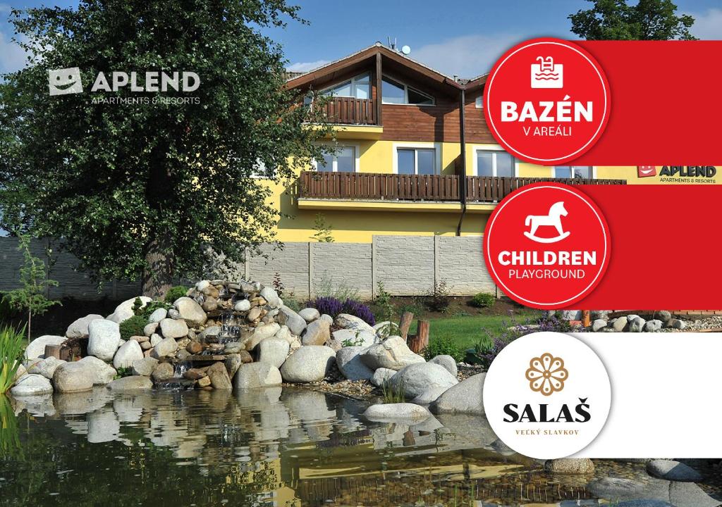 a garden with a pond in front of a house at APLEND Tatry Holiday in Veľký Slavkov