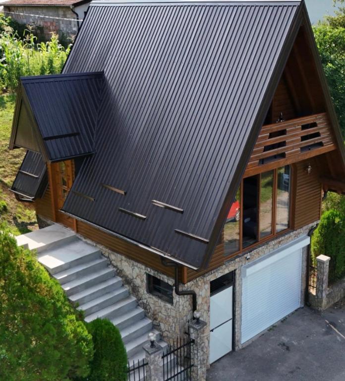 a house with a metal roof and a garage at Brvnare Sadba 