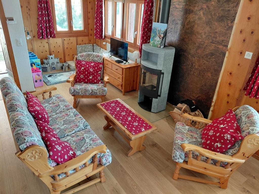a living room with couches and chairs and a fireplace at Chalet Bisse Neuf in Saint-Luc