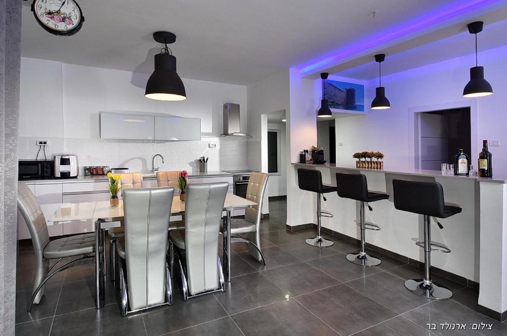 a kitchen and dining room with a table and chairs at מקום טוב באמצע במושבת כנרת in Kinneret