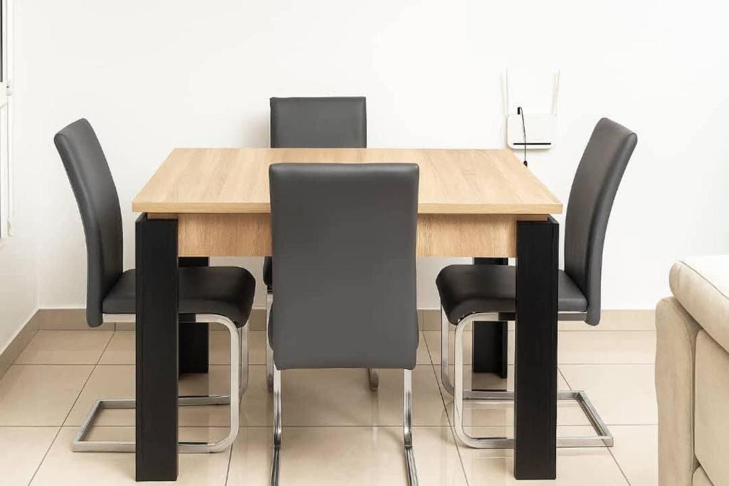 a wooden table with black chairs in a room at Chamacohouse in Cotonou