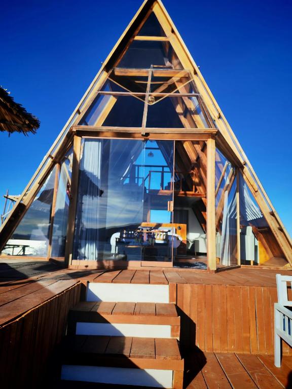a glass house with a pyramid shaped roof at Titicaca Star Perú in Puno