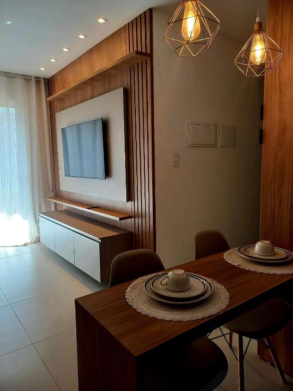 a living room with a dining table and a television at Novíssimo Altiplano 3 Quartos e Lazer Completo in João Pessoa