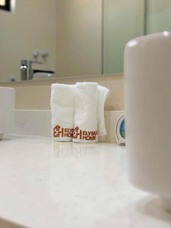 a pile of towels sitting on a counter in a bathroom at Roses Villa at Elysium Home in Dodoma