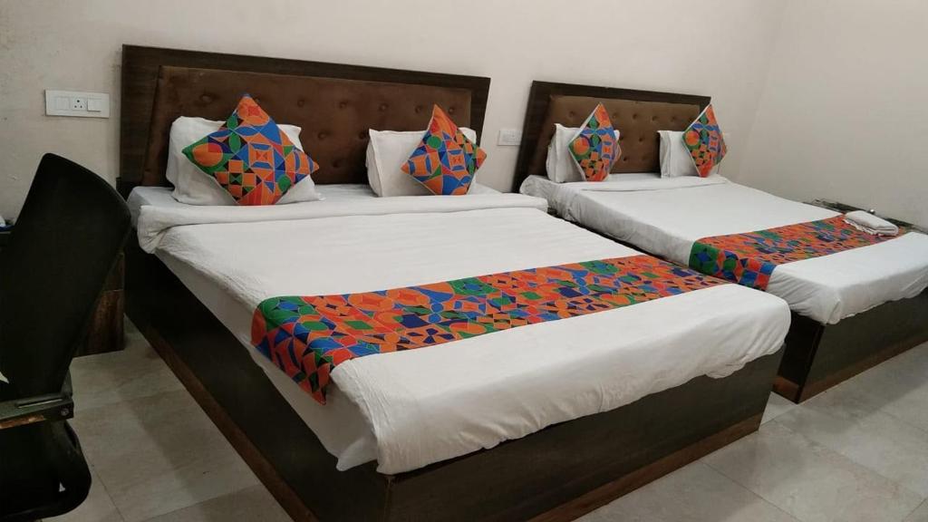 two beds in a hotel room withskirts at Sarovar Palace in Prayagraj
