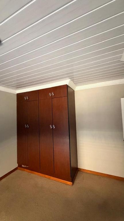 a wooden cabinet in a room with a ceiling at Trendy Tranquility in Secunda