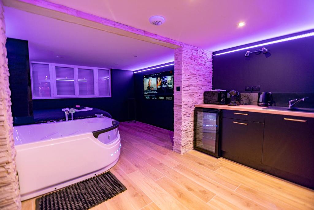 a bathroom with a white bath tub next to a kitchen at Cristal Room in Rochefort