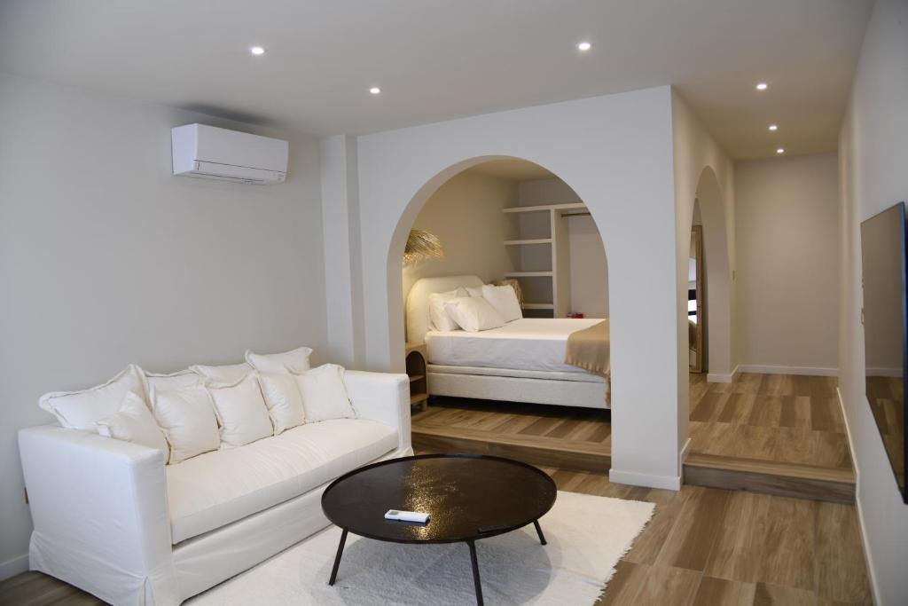 a living room with a white couch and a bed at Amber Apartments in Jávea