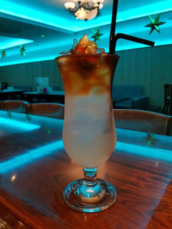 a drink sitting on top of a wooden table at Caisleain Oir Hotel in Annagry