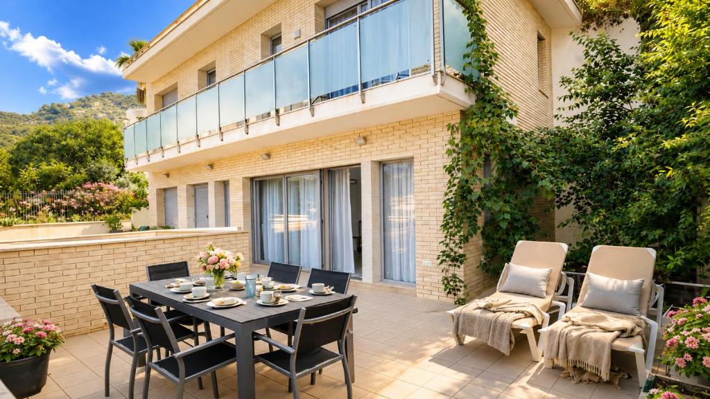 a patio with a table and chairs and a building at Spacious Duplex in Sitges with Sea Views, Terrace & Free Parking Area in Sitges