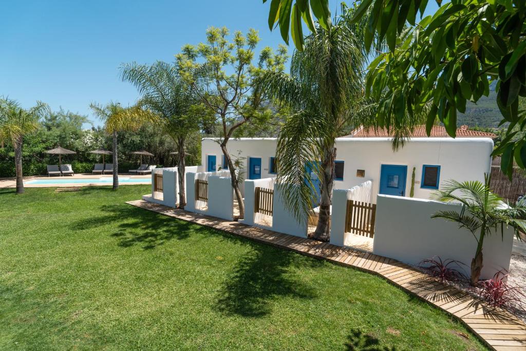 a white house with a fence and a yard at Boho Suites Denia in Denia