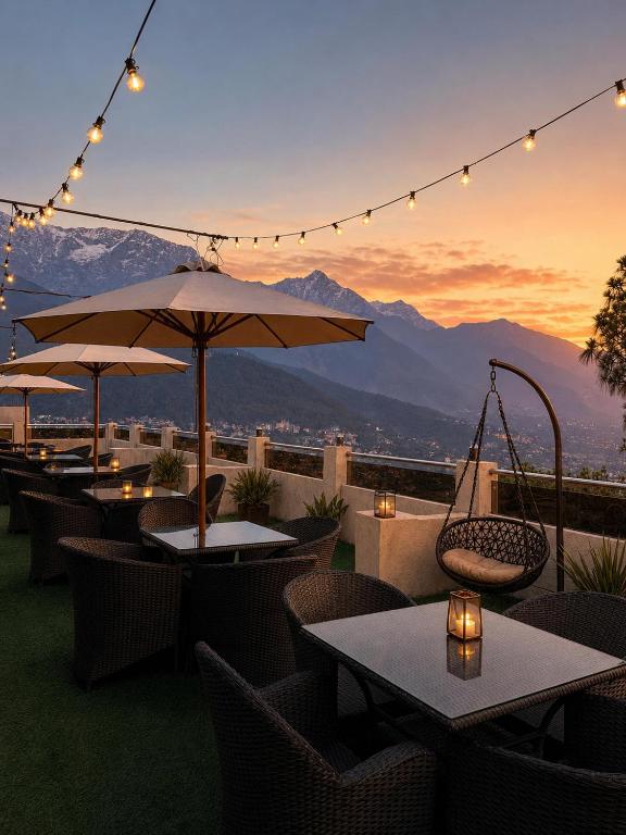 a patio with tables and umbrellas with a view at The Zinnia Castle- Dharamshala # Centrally Heated & Air Cooled # Premium Rooms # Lift # Bar # Terrace # Big Parking # Near market # Top Rated # Property of the year in Dharamshala