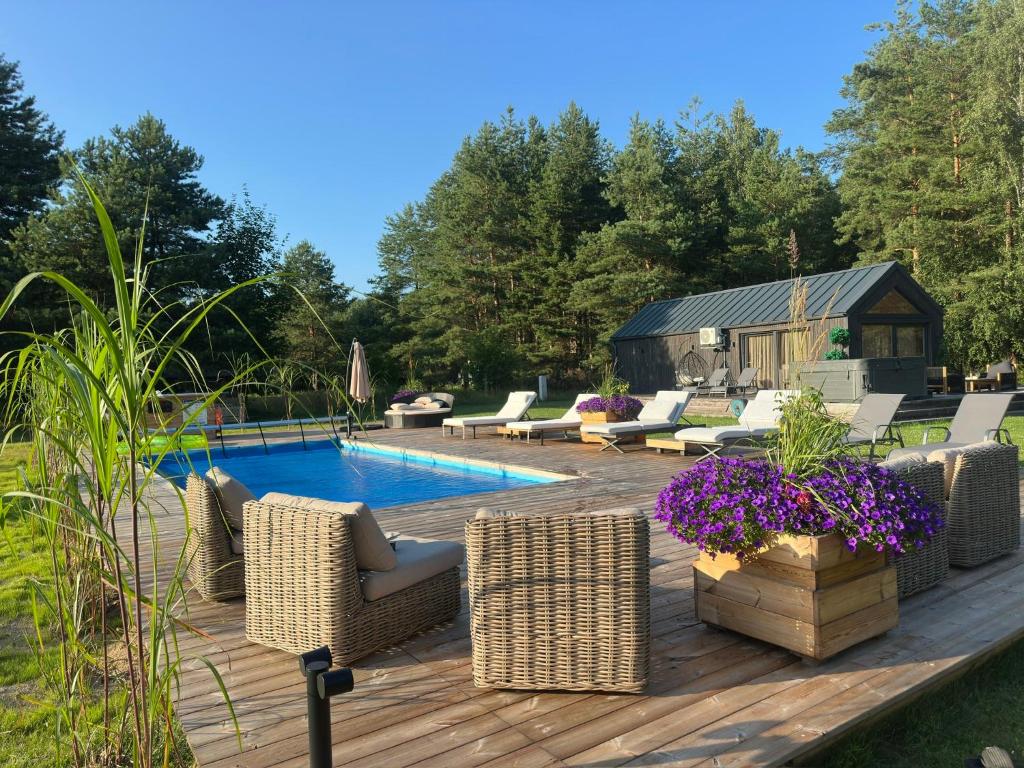 a patio with wicker chairs and a swimming pool at Paežerės istorijos near Druskininkai in Veršiai