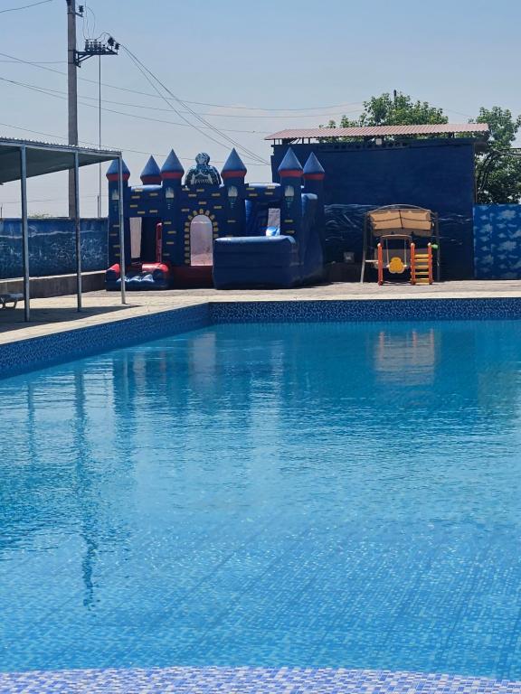 a large swimming pool with a playground in the background at NectaraVilla PooL in Ashtarak
