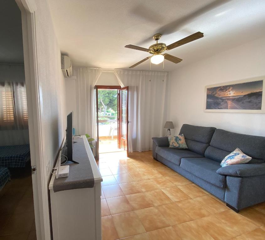 a living room with a blue couch and a ceiling fan at Apartment with private balcony in San Javier