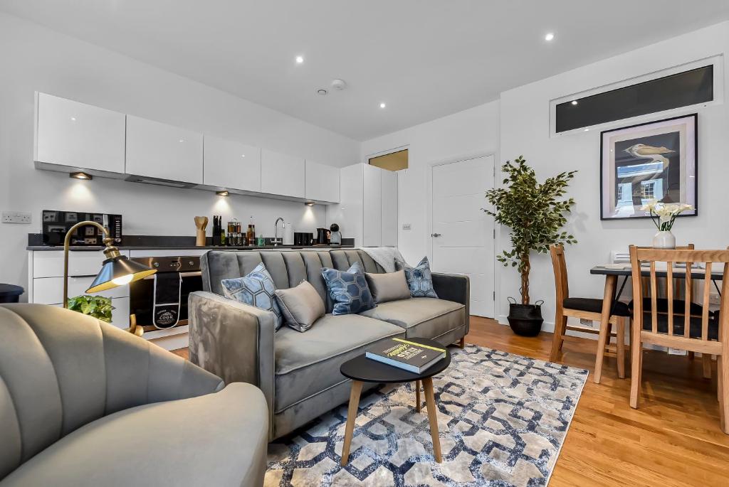 a living room with a couch and a table at Newly Reopened, Modern Flat Central Location in Staines