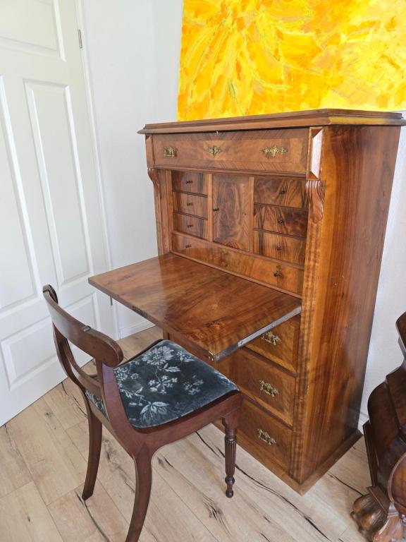 a wooden desk with a chair next to a dresser at Zimmer im Oldenburger Dobbenviertel in Oldenburg