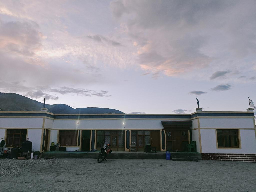 a building with a motorcycle parked in front of it at Deachen Khangsar in Spangmik