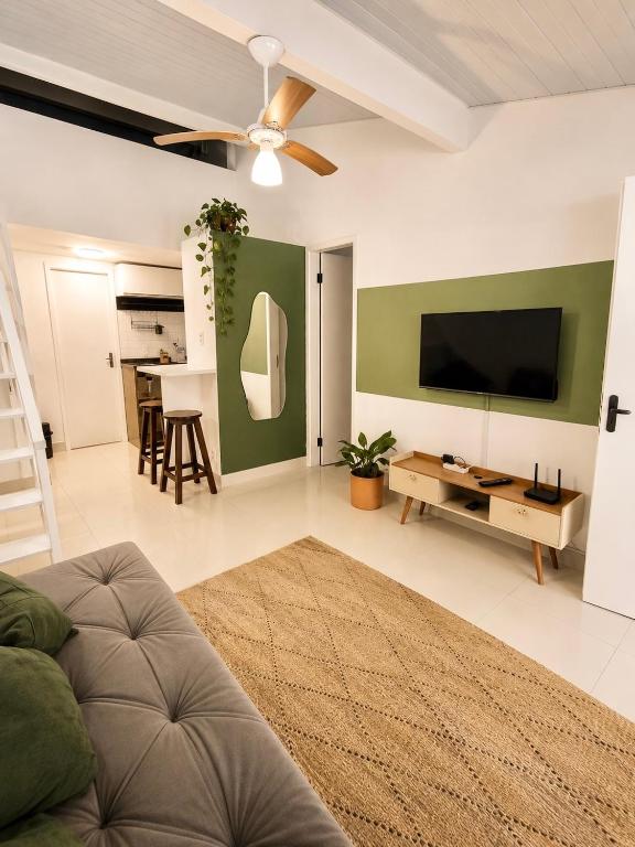 a living room with a flat screen tv and a couch at Apartamento em Condomínio - Centro de Búzios in Búzios