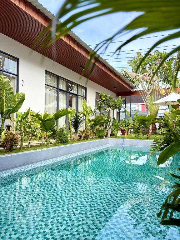 a swimming pool in front of a building with a house at Samphia Homestay in Nguyệt Hòa