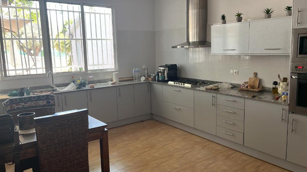 a kitchen with white cabinets and a counter top at Nirvana camp in Matola
