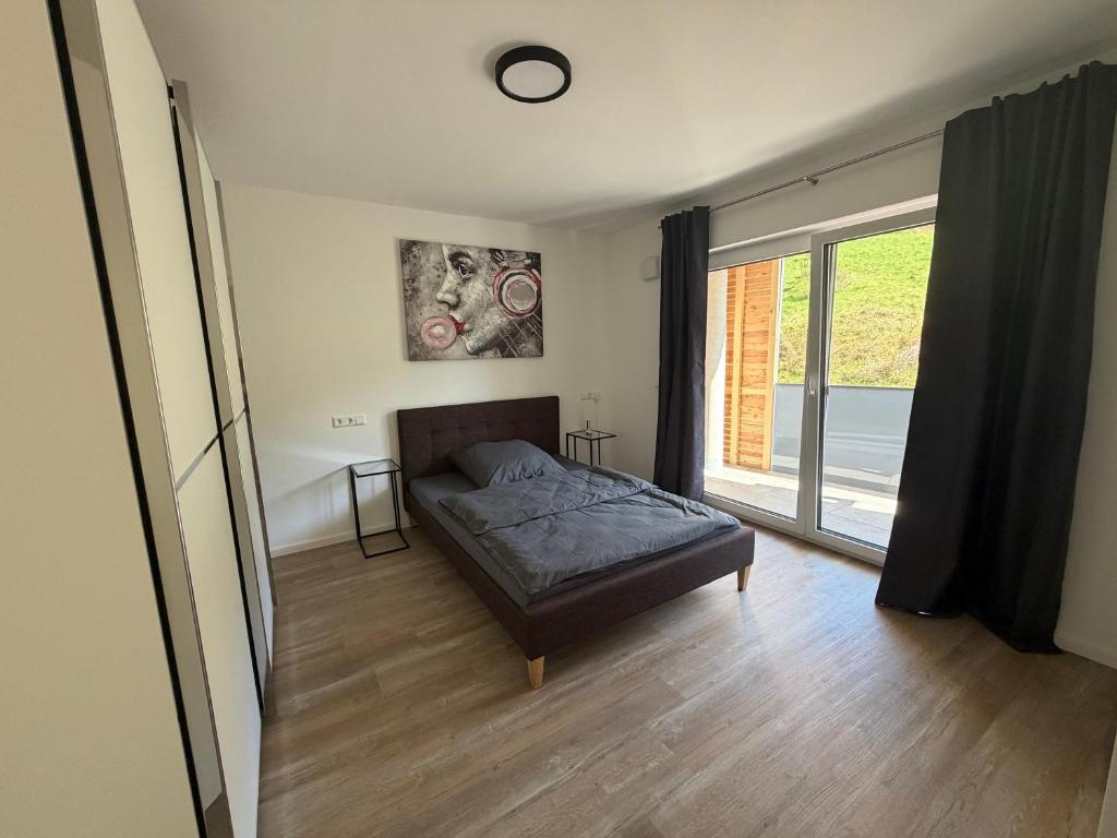 a bedroom with a bed and a large window at FeWo Alissa in Nordrach
