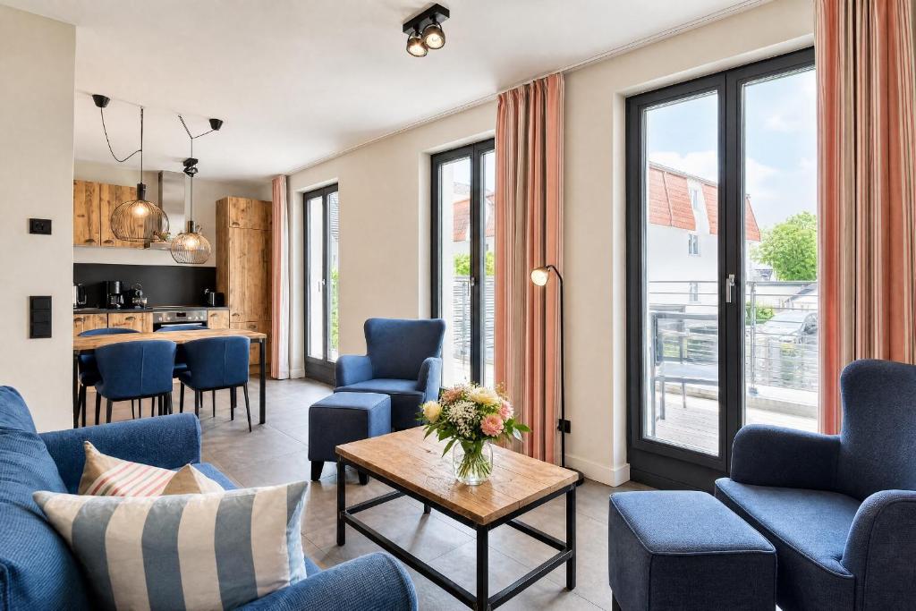 a living room with blue chairs and a table at Ferienwohnung Heimathafen Villa Martha Binz in Binz