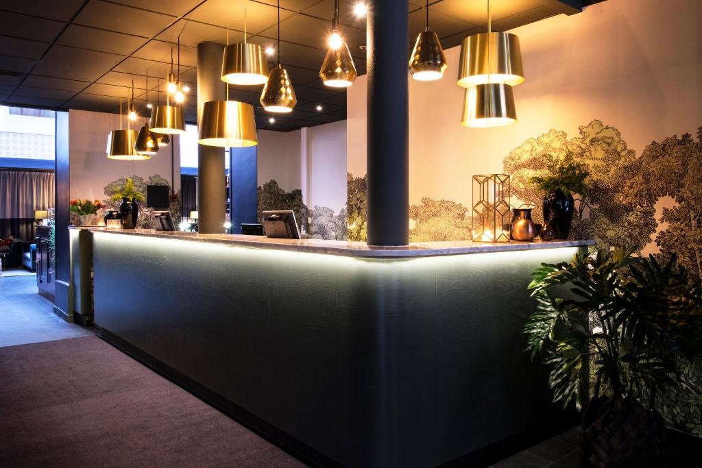 a bar in a restaurant with pendant lights at Clarion Collection Hotel Temperance in Malmö