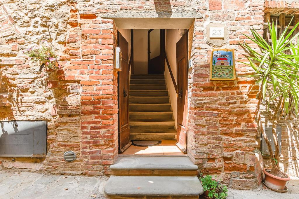 a brick building with a staircase leading to a door at Casa Luana in Lucignano